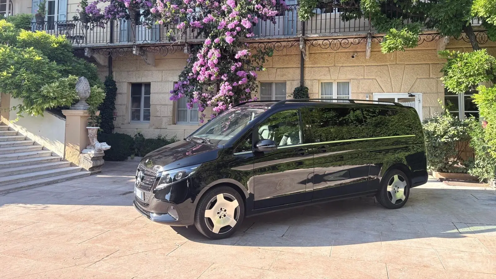 Mercedes Classe V all'ingresso di un hotel elegante con glicine e buganvillea