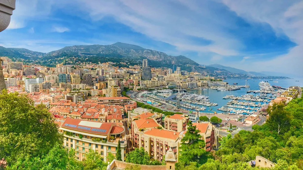 Vista panoramica sul porto di Monte Carlo con gli yacht e le colline di Monaco sullo sfondo