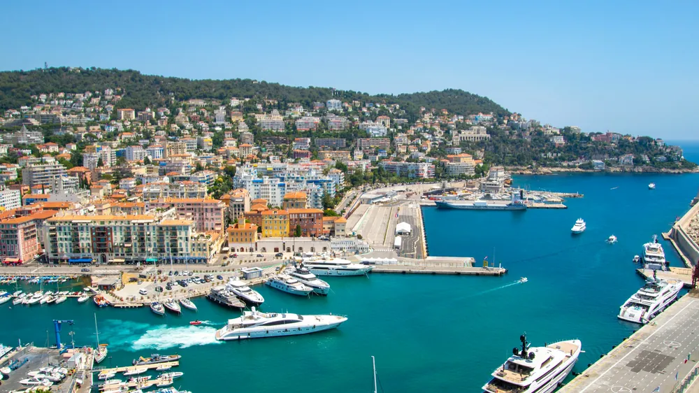Il porto Lympia di Nizza con gli yacht e le colline colorate sullo sfondo